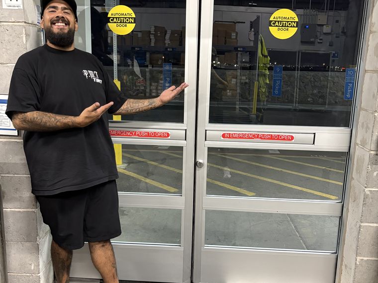 Marcos of PMT Tint beside a freshly tinted commercial entry door in El Paso